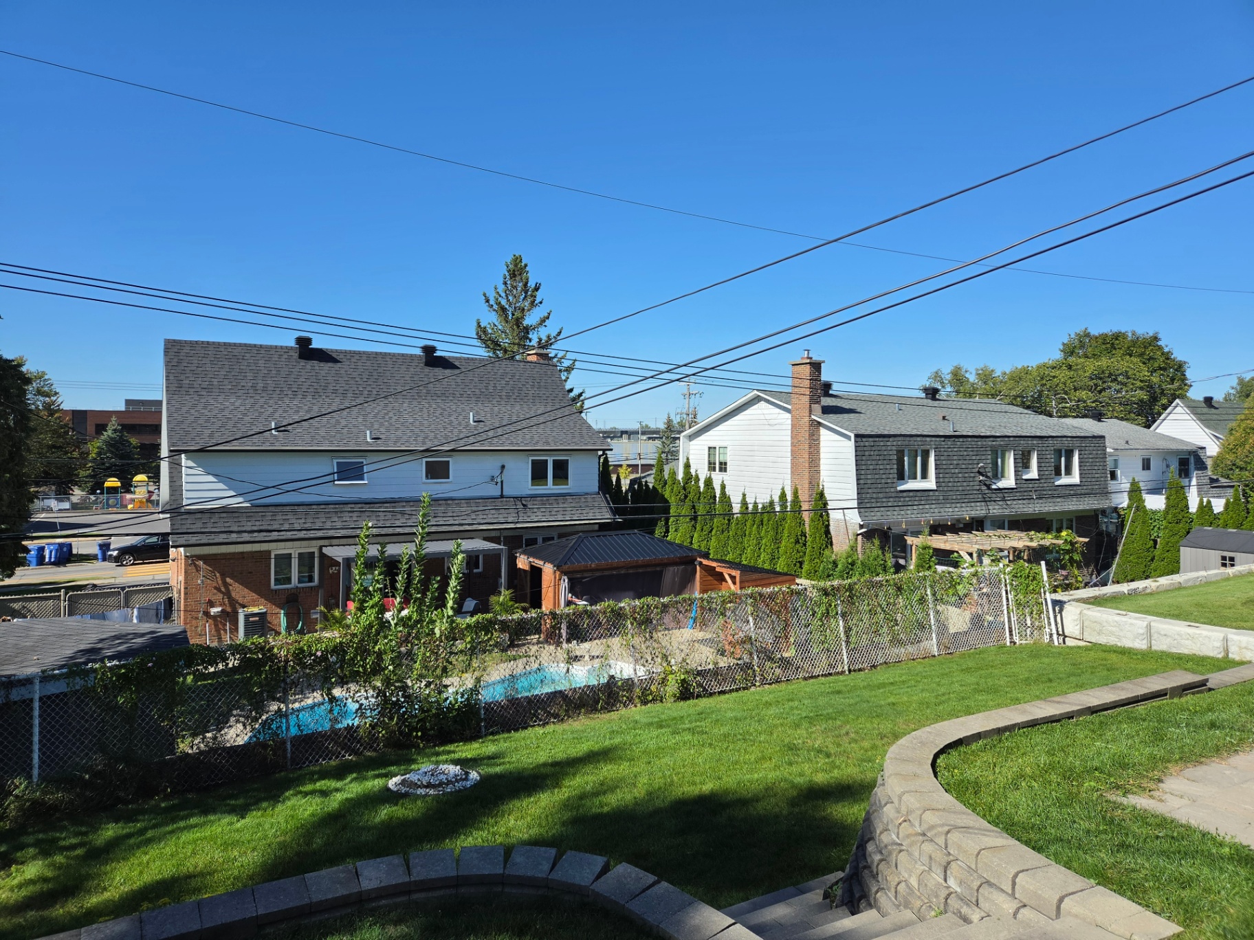 Maintained backyard lawn with a curved stone retaining wall