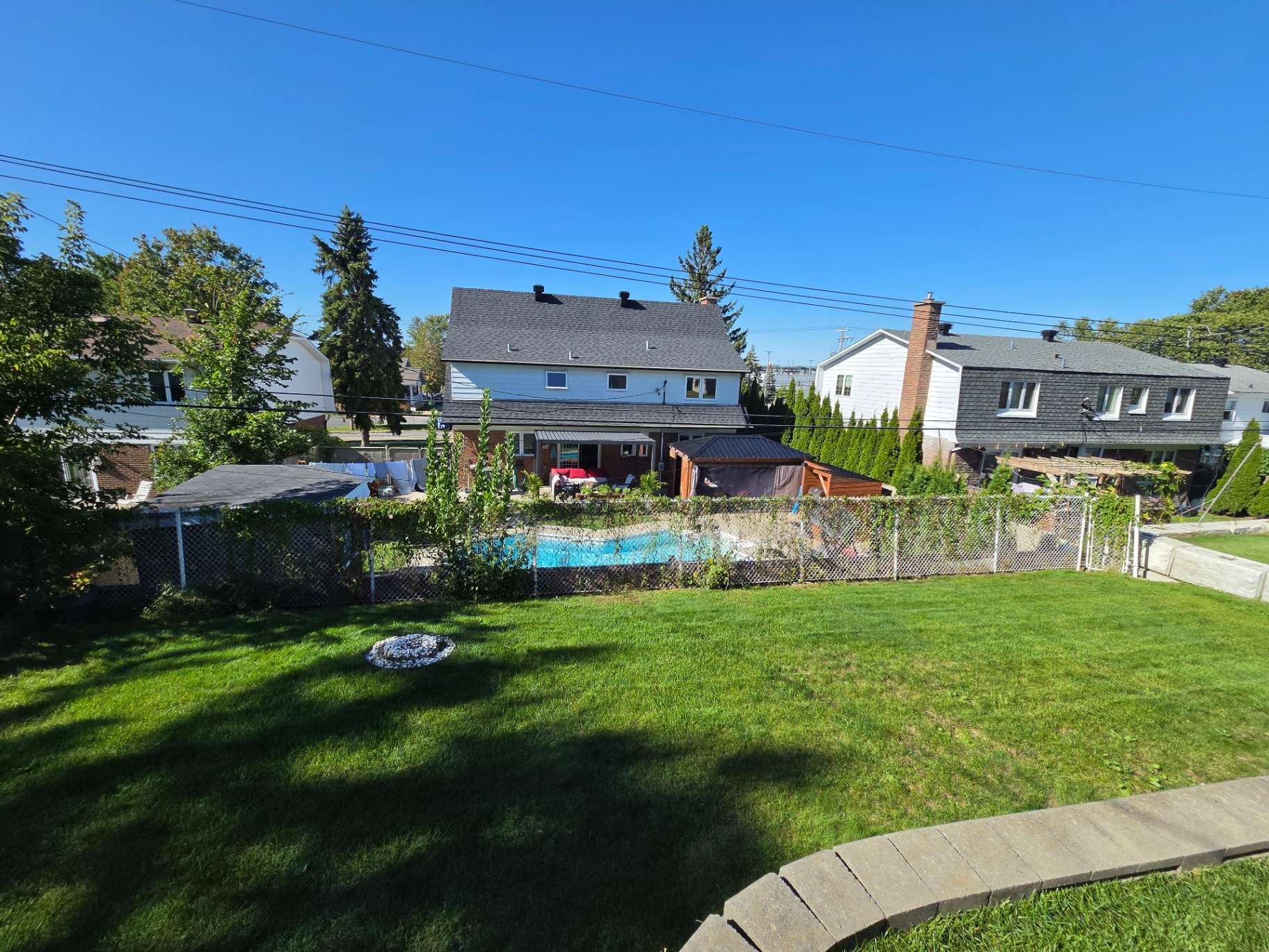 Freshly maintained backyard lawn with a pool in the West Island
